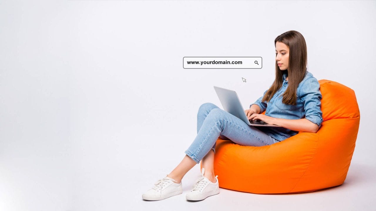 A Pretty Girl Working On Bean Bag With Laptop
