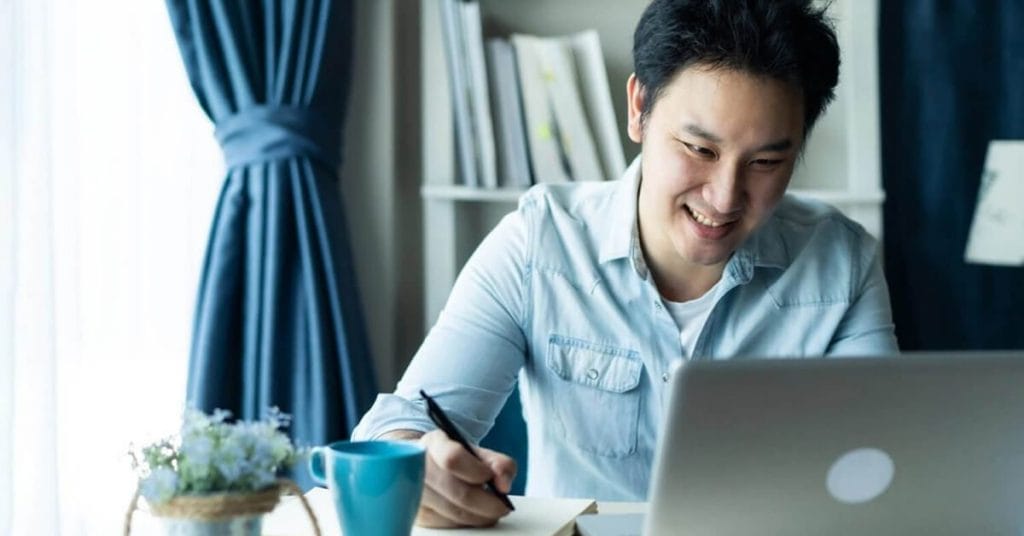 Happy Man Working In Front Of Laptop